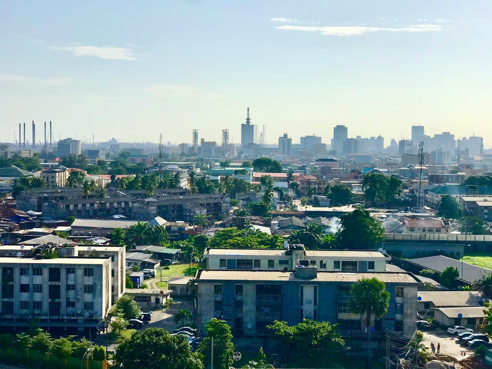 Aerial view over the dense rooftops and low-rise buildings of Lagos, Nigeria, seen from above in daylight.