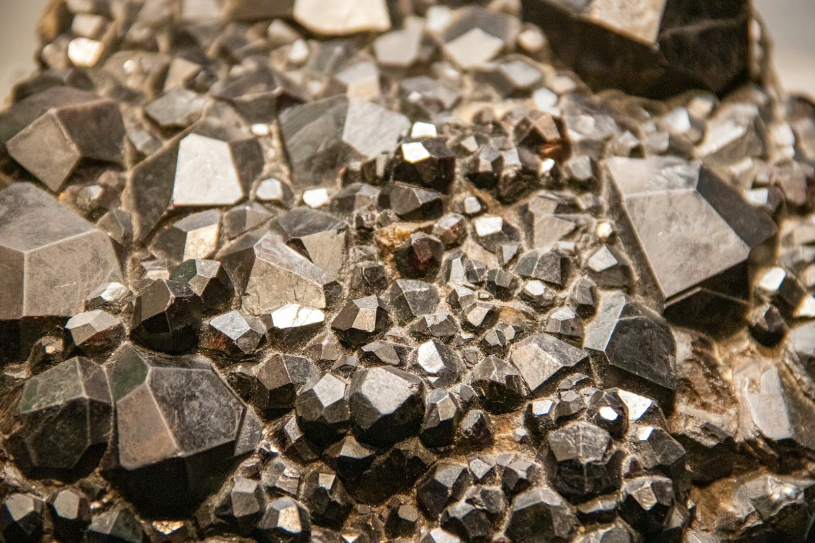 Macro photograph of rough grey and black uncut stone fragments laid on a flat neutral surface, unpolished and unstyled.