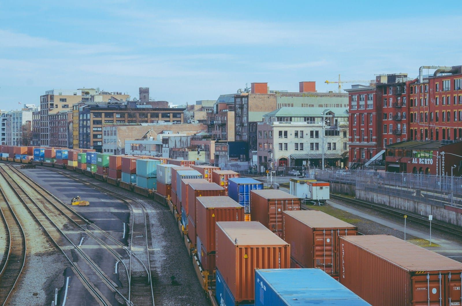 A freight rail yard filled with rows of cargo wagons stretching into the distance.
