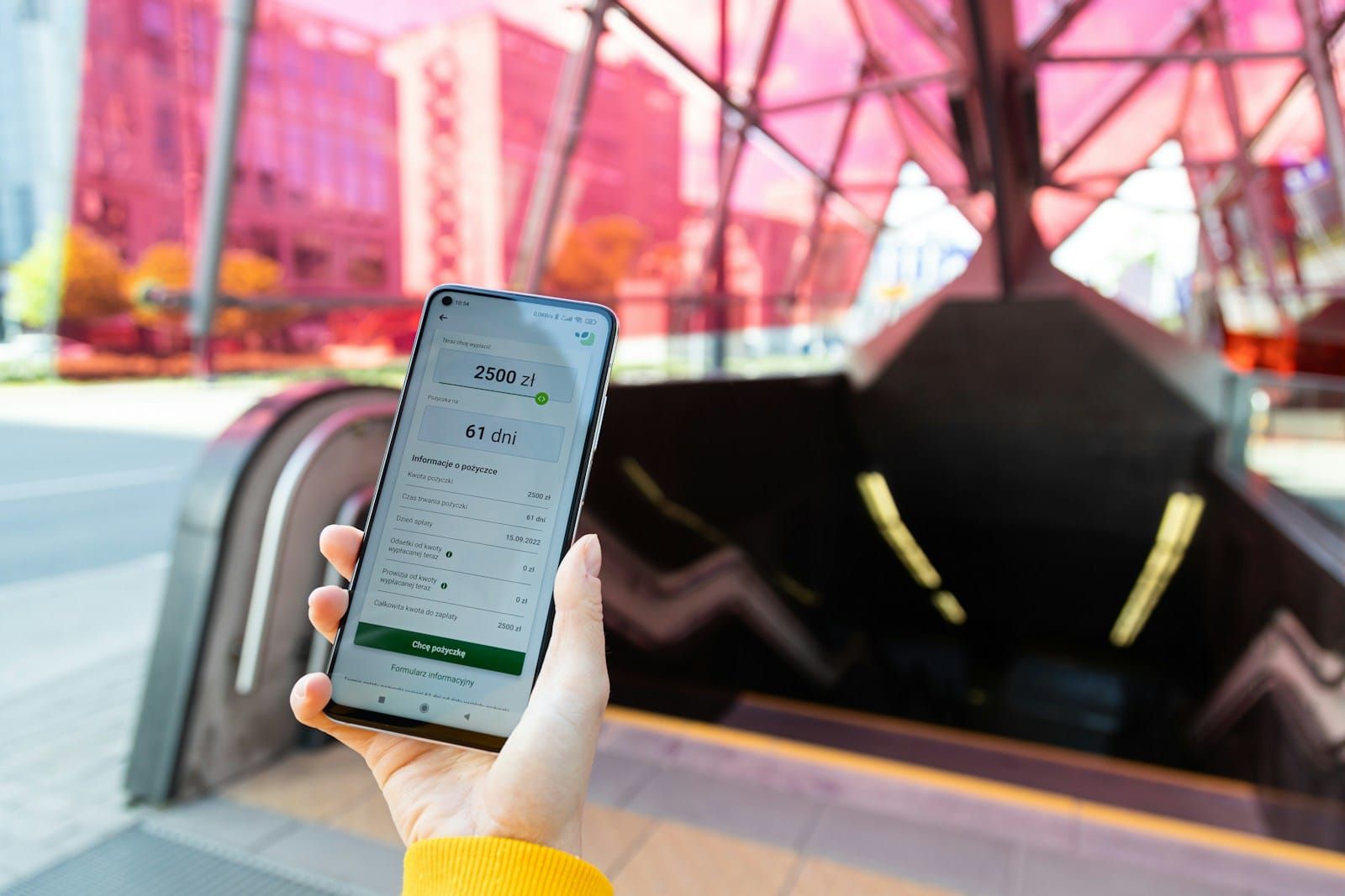A hand holding a mobile phone showing a financial app, shot close in with no visible branding.