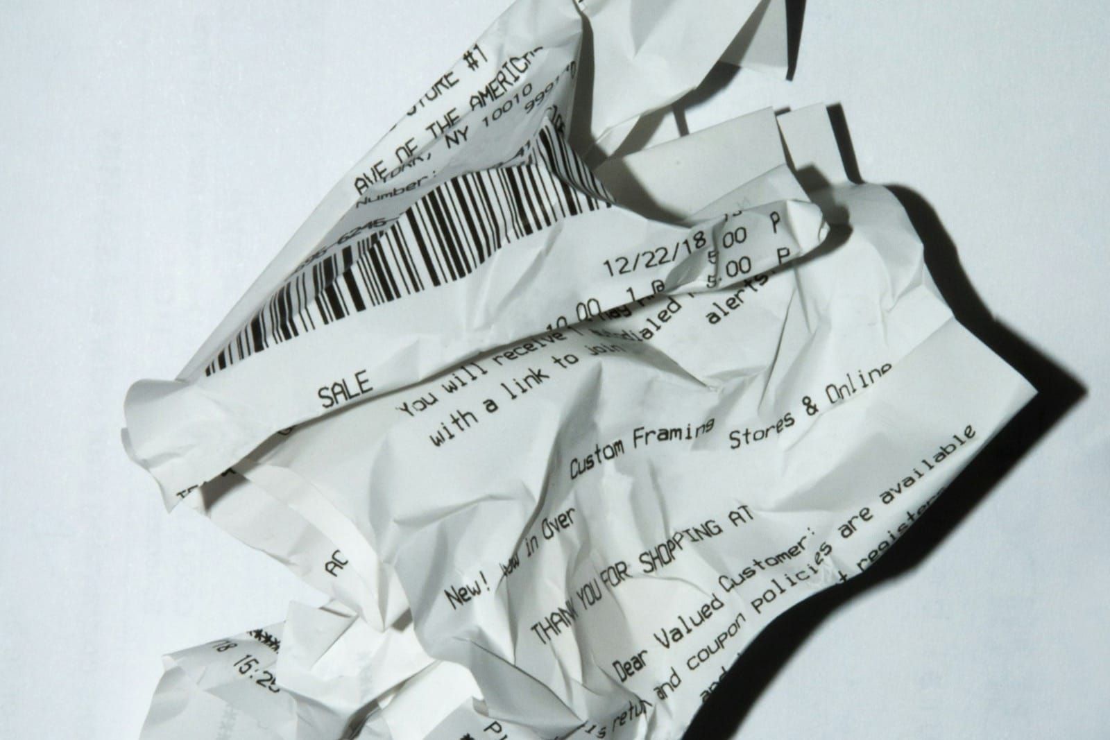 A printed paper receipt lying on a plain white surface in muted grey tones, no hands or storefront branding.