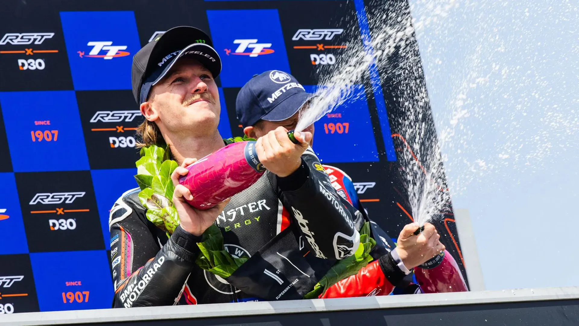 Davey Todd sprays champagne after winning the Superbike race