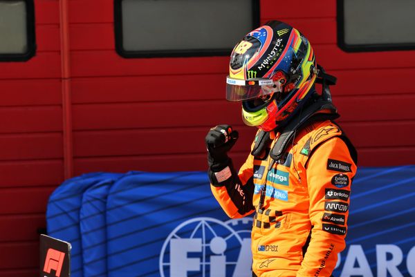 Oscar Piastri celebrates 2025 Imola pole wearing race suit and helmet