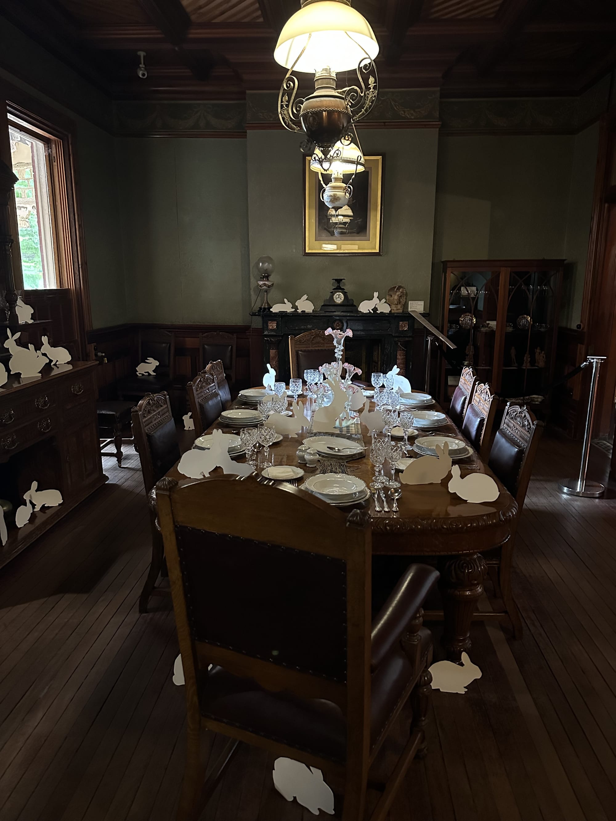 A fancy room set for a dinner party with white rabbits everywhere.