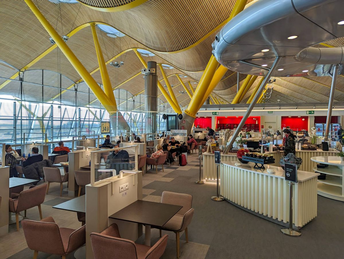 Airport lounge showing yellow support beams and an undulating ceiling