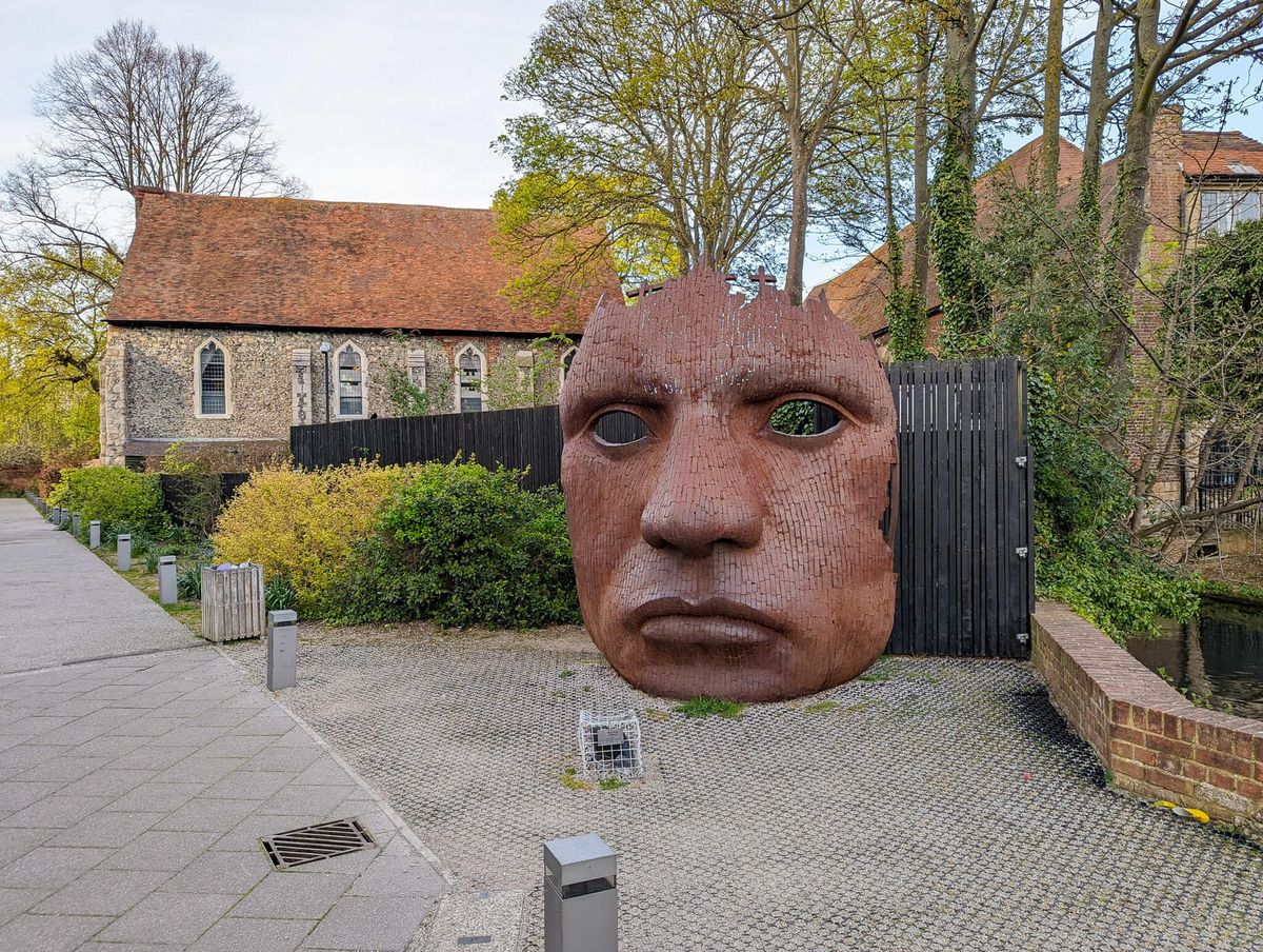 Large sculpture of a face, presented as a mask