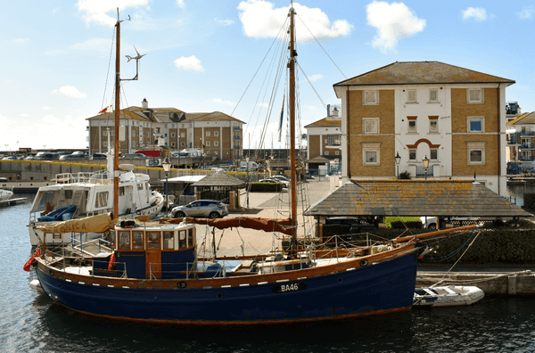 Sailboat in a harbor in front of apartment buildings - Moral Letters to Lucilius