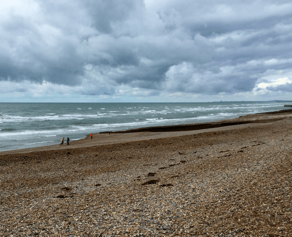 A rocky beach on the ocean under a cloudy sky