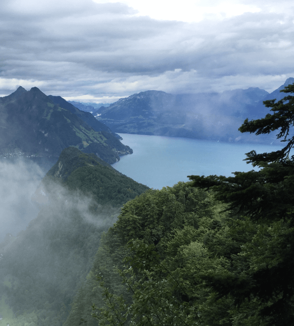 Light mist shrouding wooded mountains with a lake in the background