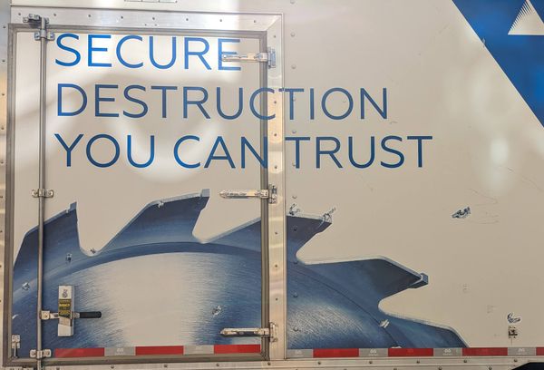 Truck panel reading "Secure Destruction You Can Trust" above a saw blade