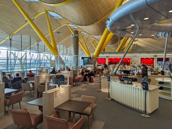 Airport lounge showing yellow support beams and an undulating ceiling