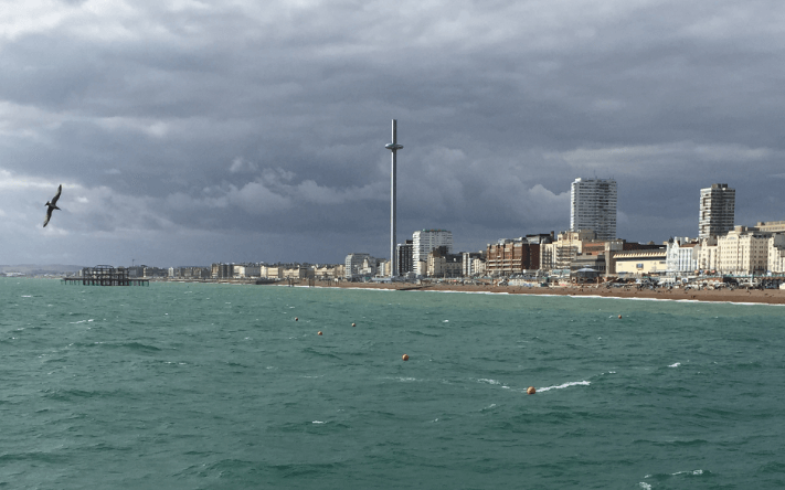 View of British seaside from far out in the choppy, green water under a bruised, gray sky