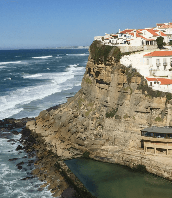 Whitewashed houses lining a dramatic cliff above the Mediterranean sea