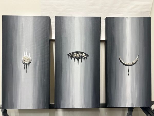 Three paintings in a grayscale gradient with different symbols on each displaying the different stages of Grief. Each symbol has cremains in it