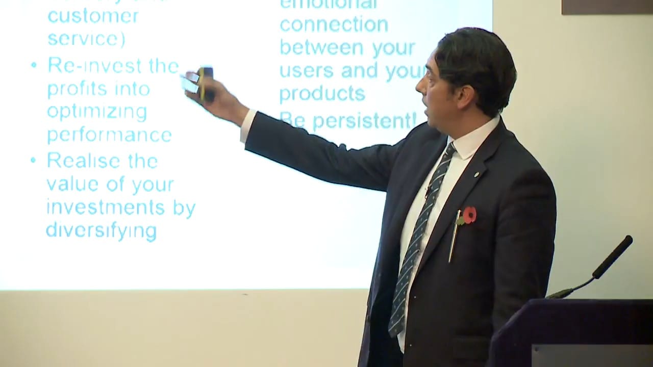 Elliott King on the lessons of the dot-com survivors, IoD London Elliott King pointing to a slide on customer service, reinvestment and diversification at the IoD in London