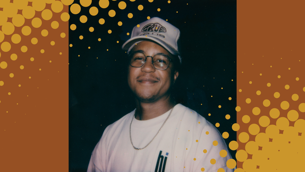 Image of Van Newman, who is a Black man wearing a trucker hat, glasses, a white t-shirt, and a gold necklace.