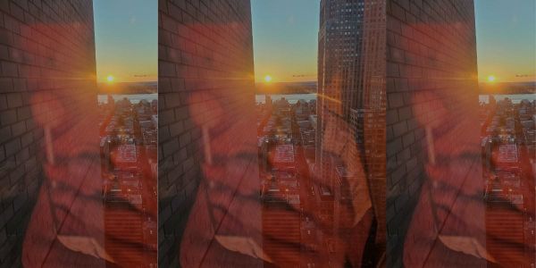 That's the back of my phone reflected capturing a sunset over a New York city skyline July 2023