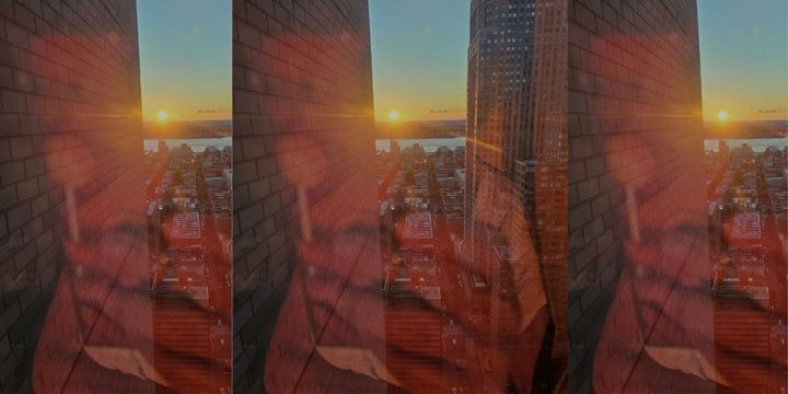 That's the back of my phone reflected capturing a sunset over a New York city skyline July 2023