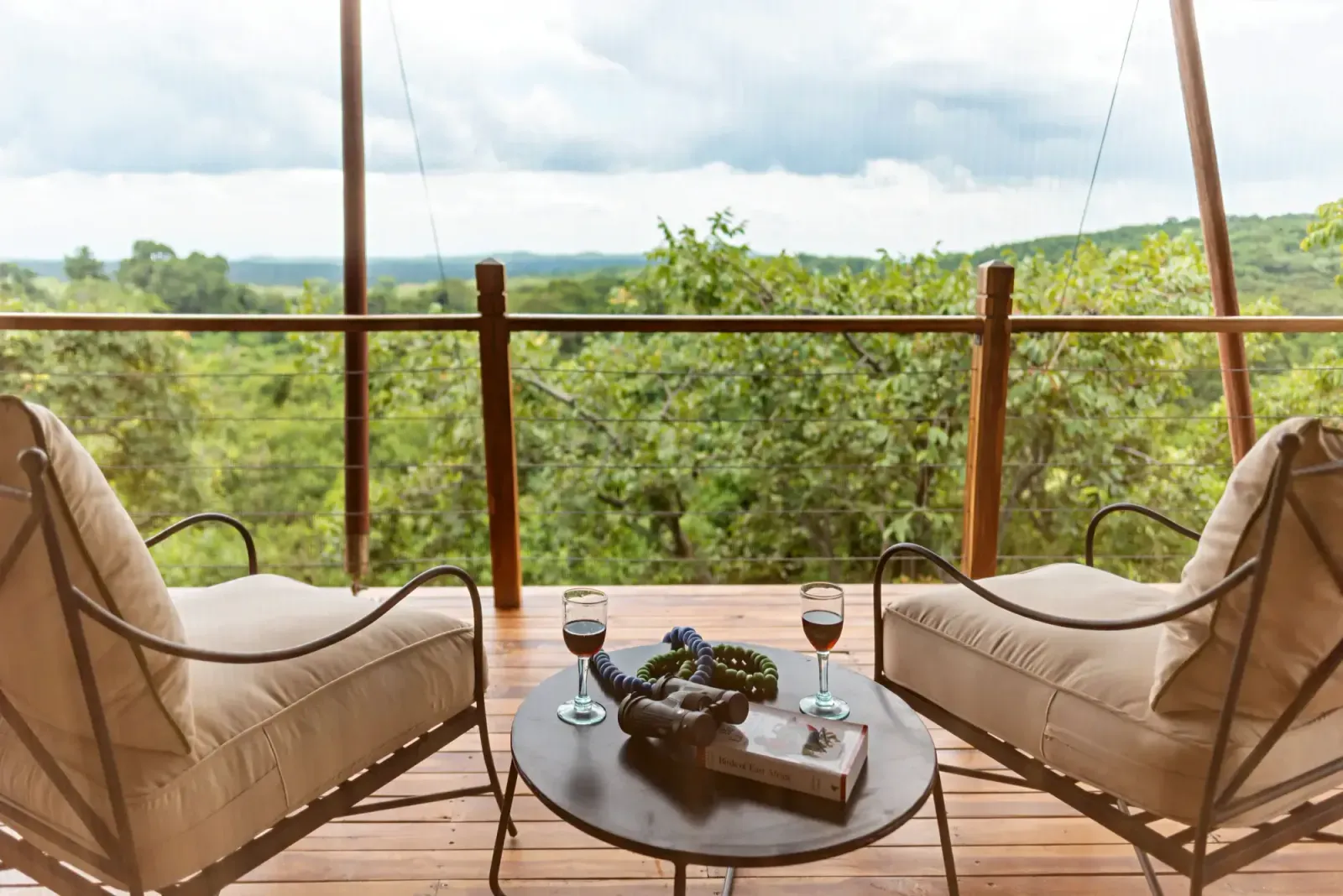 Armchairs on a tented suite deck overlooking the forest at Pabidi Lodge