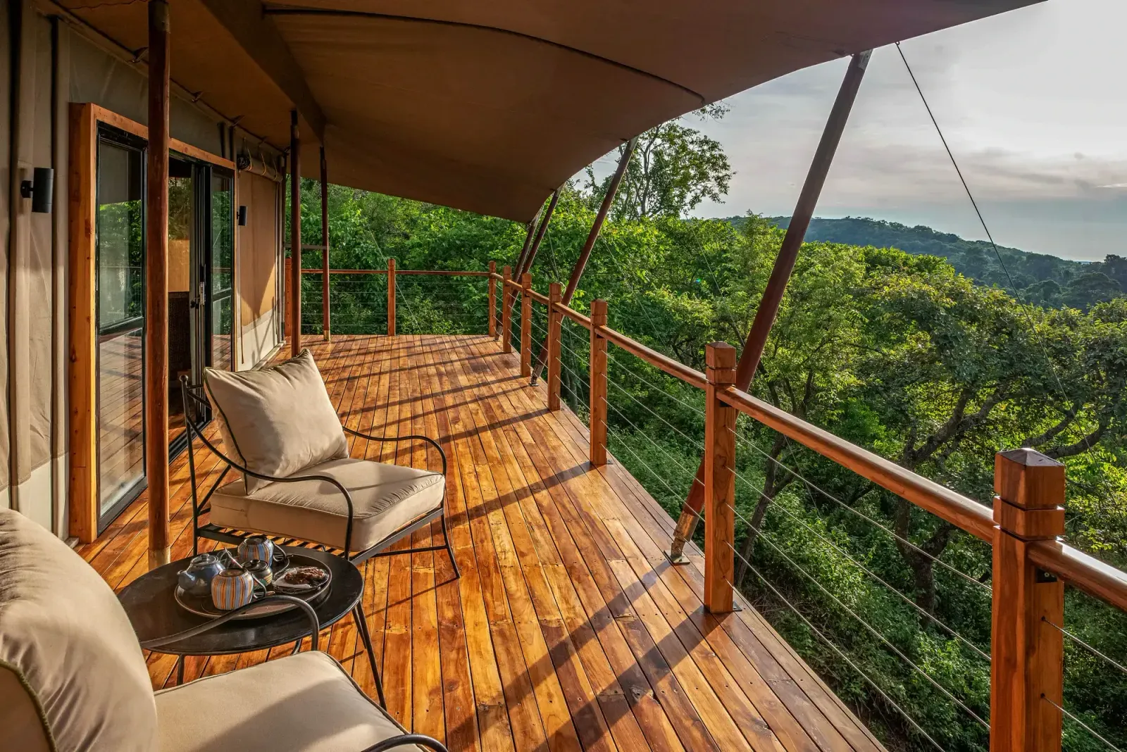 The private deck of a luxury tented suite with forest views at Pabidi Lodge