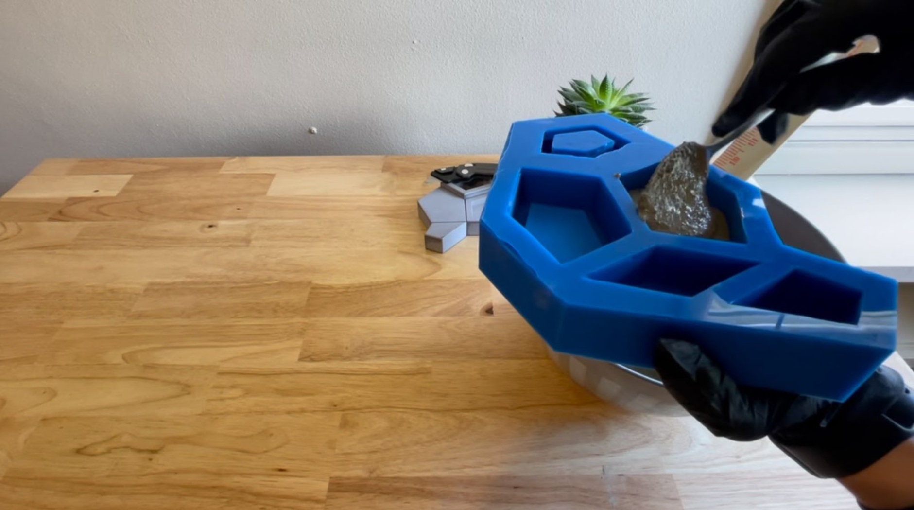 Carefully filling the silicone mold with the concrete mixture.