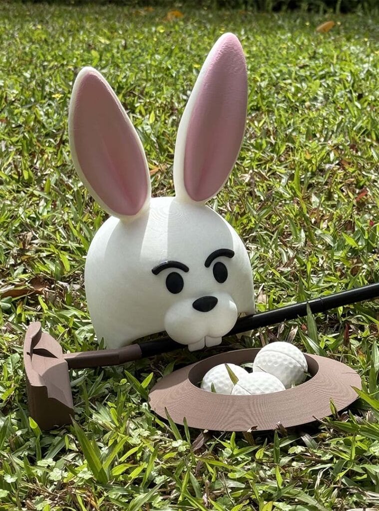A 3D Printed Bunny Head Golf Goal with Golf Set on lawn outdoor.