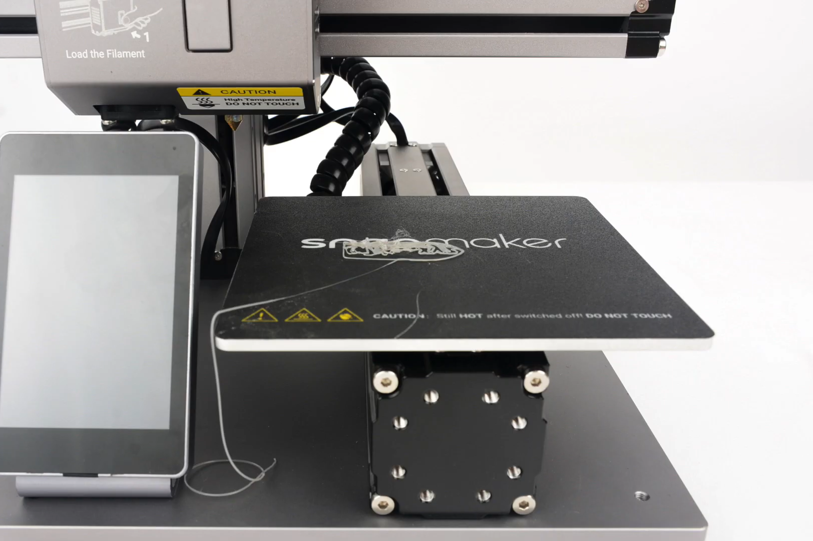 Close-up of a Snapmaker 3D printer bed with a tangled and failed first layer, demonstrating poor adhesion.