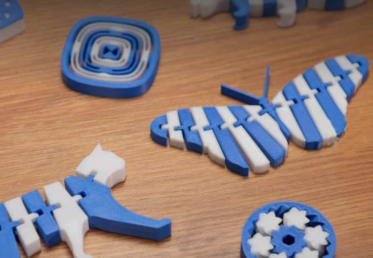 Blue-and-white articulated models that can be created on any printer using the single extruder method by pausing to manually swap filament colors.