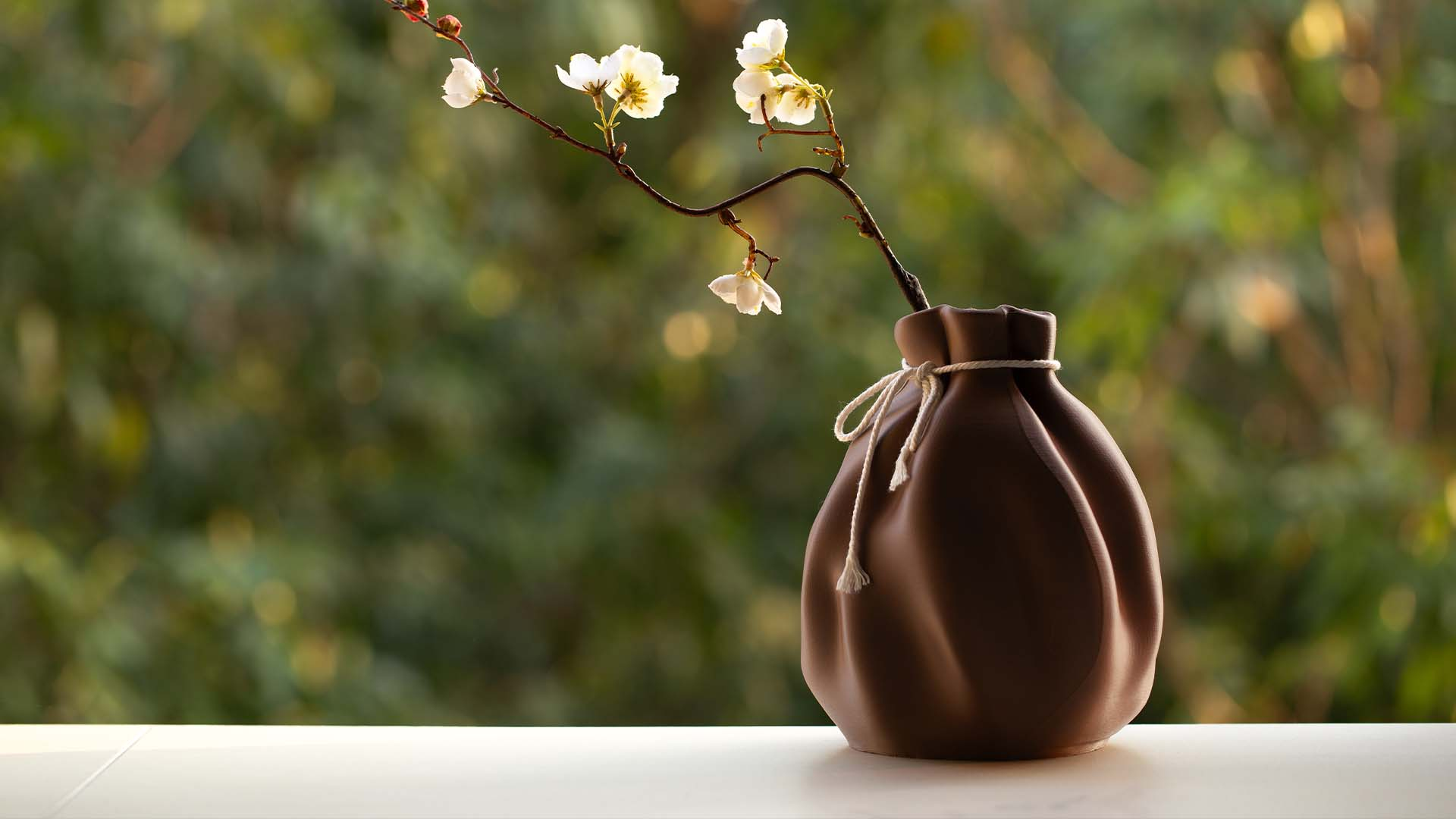 A decorative brown 3D printed vase with a drawstring bag texture, an easy 3D printing idea for home decor.