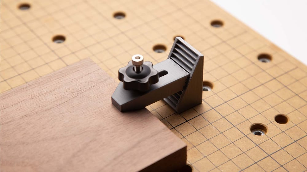 A practical 3D printed low-profile clamp used as a workshop tool to hold wood on a CNC bed.