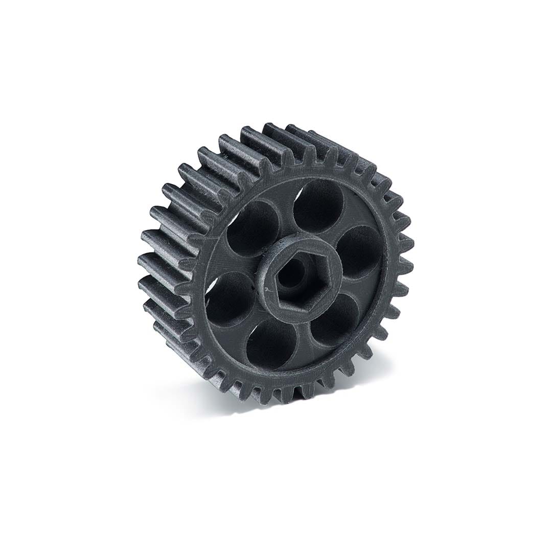 A close-up of a strong, functional 3D printed gear made with black filament, showcasing a part designed for heavy-duty use with optimized infill and walls.
