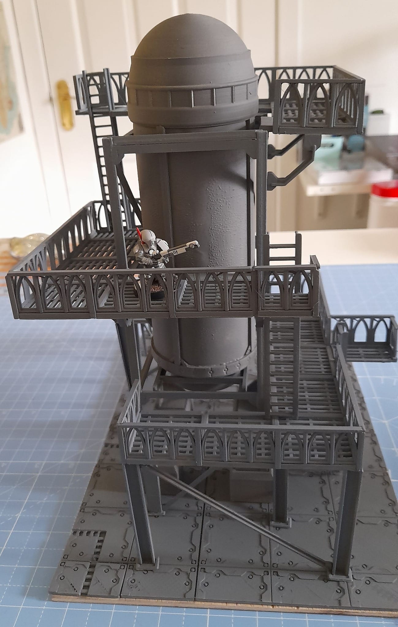 A complex and highly detailed architectural model of a multi-story building sits on a wooden base.