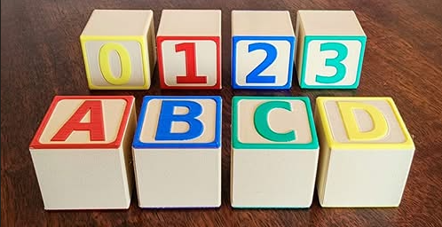 A set of colorful educational blocks, some with letters and some with numbers, sit in a stack.