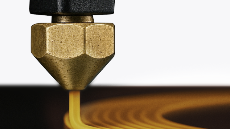 Close-up of a brass 3D printer nozzle extruding filament, showing the thermal conductivity and smooth flow of plastic.