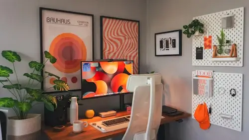 Creative home office with two white pegboards on the wall, decorated with plants, posters and custom 3D printed accessories.