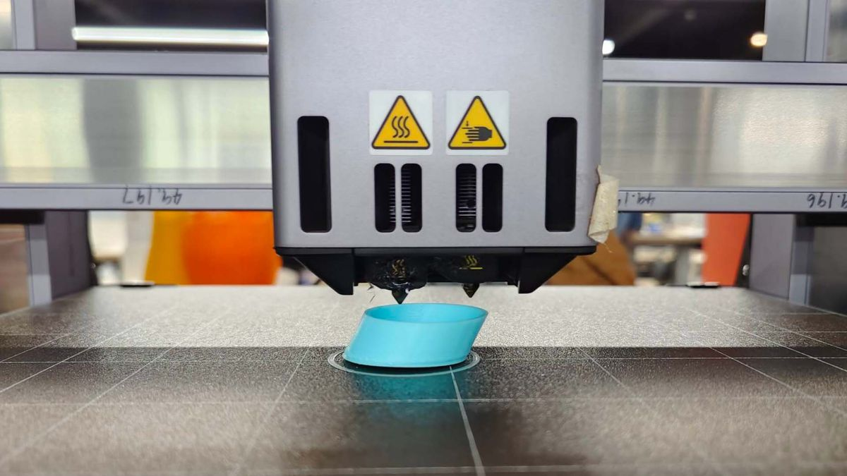 Close-up of a 3D printer extruder over a print bed, showing where layer shifts can occur due to lubrication issues.