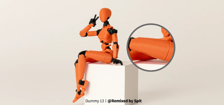 An orange and black 3D printed Dummy 13 articulated humanoid figure sitting on a block, illustrating a posable mechanical skeleton frame that bypasses complex joint calibration.