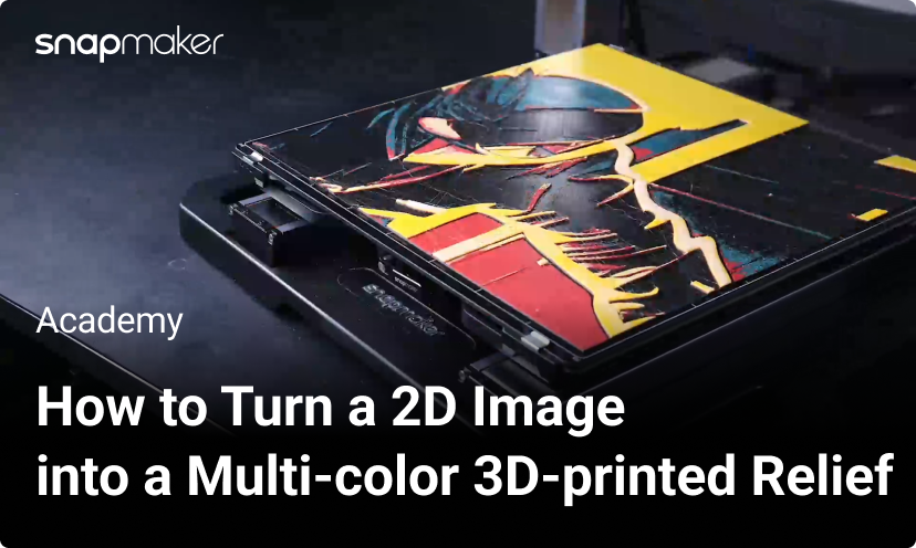 Image of a Snapmaker 3D printer with a multi-color 3D-printed relief on its print bed, featuring a vibrant design with red, yellow, and black layers.