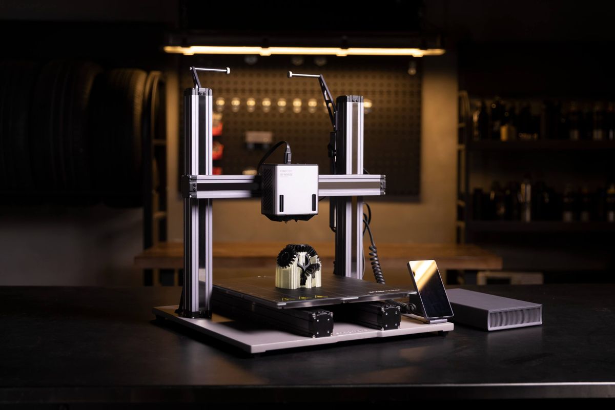 A modern dual extrusion 3D printer creating a two-color gear model, illustrating the capabilities of multi-material printing.