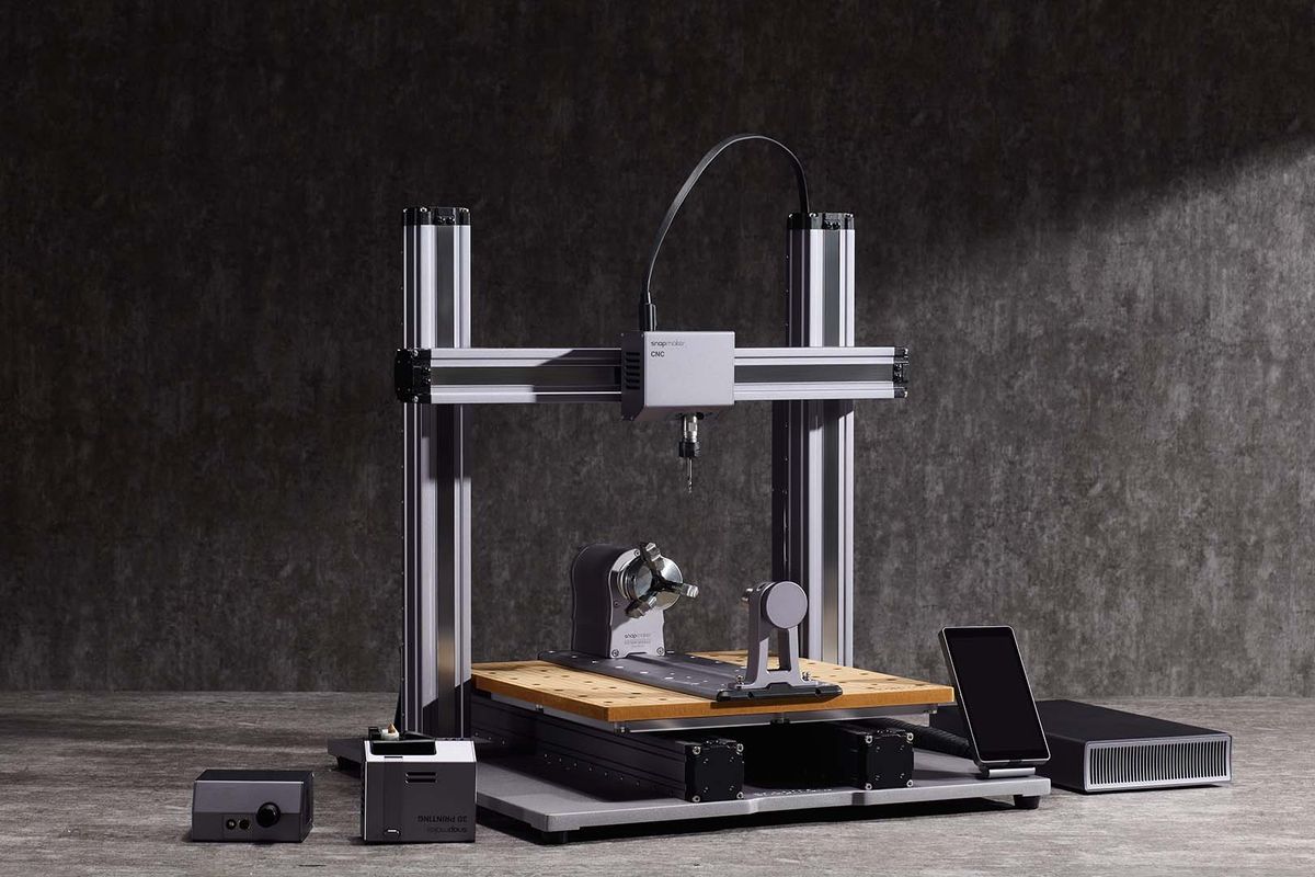 A Snapmaker CNC machine with a wooden worktable, equipped for precision milling, shown with a tablet and additional modules against a dark industrial background.