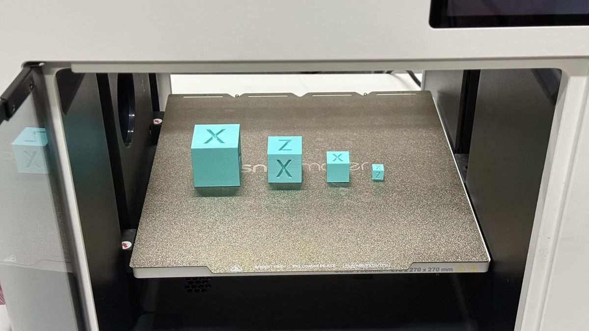 A set of cyan calibration cubes in various sizes printed on a Snapmaker build plate, ready for dimensional accuracy testing.