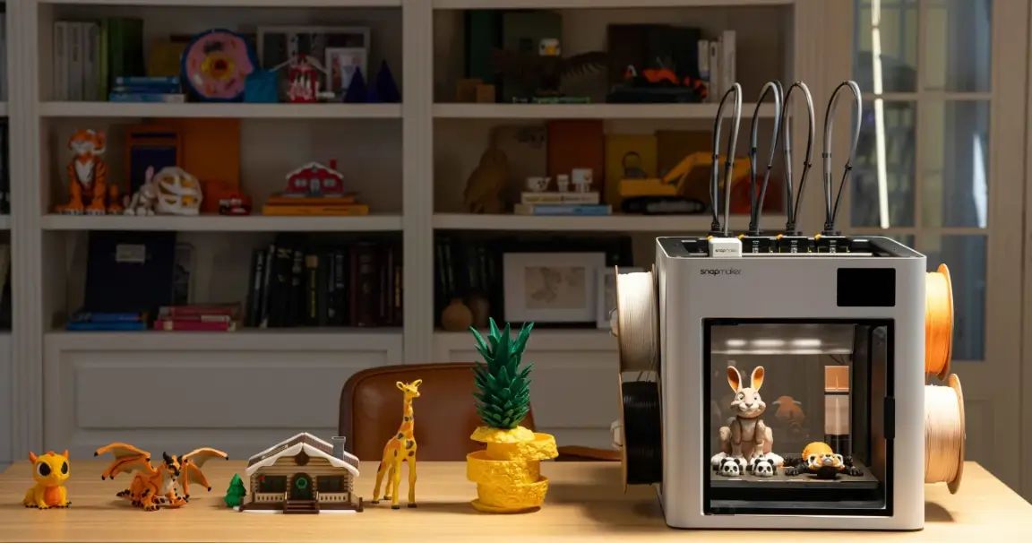 Snapmaker 3D printer surrounded by a variety of finished 3D printed projects including toys, decor and figurines, showing what you can print with a 3D printer.