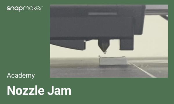 A photo of a 3D printer nozzle above a print bed, with the Snapmaker logo and text "Academy: Nozzle Jam" on a green background, illustrating a common 3D printing issue.