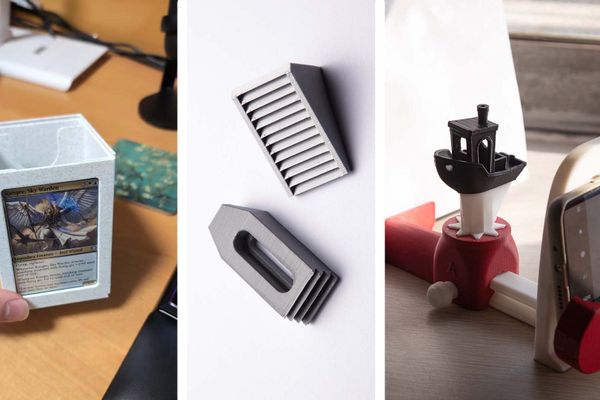 Three 3D-printed items: a card box holding a trading card, a stepped clamp for CNC workholding, and a photography rig with a 3DBenchy model and smartphone mount.