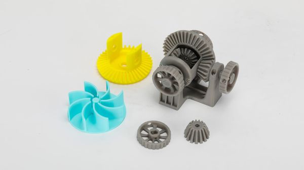 Functional, mechanical PLA 3D prints, including a complex gear assembly.