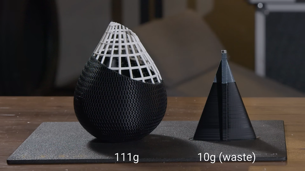 A side-by-side comparison showing a 111g 3D printed model next to the small 10g purge tower, demonstrating how much filament can be wasted during purging.