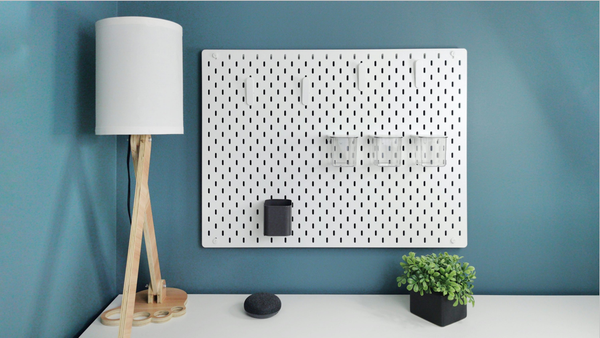 Minimalist workspace with pegboards on the wall, showing a clean desk setup ready for 3D printed accessories.