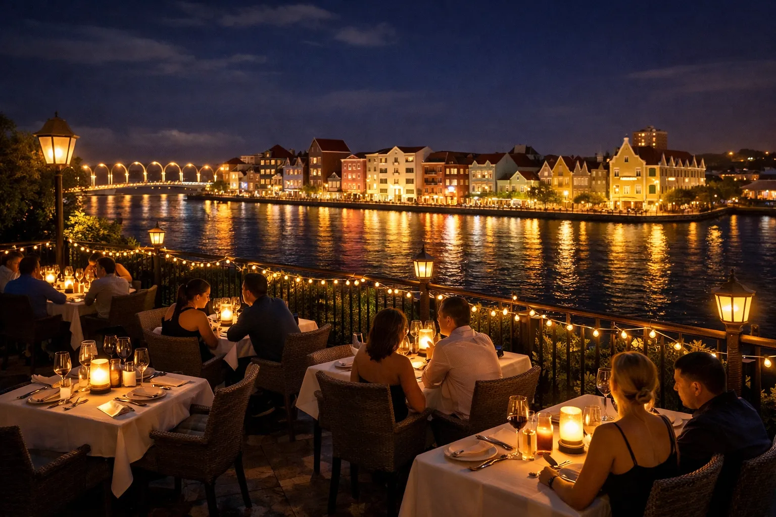 Open-air terrace at Gouverneur de Rouville above Otrobanda waterfront at night. Candlelit tables.