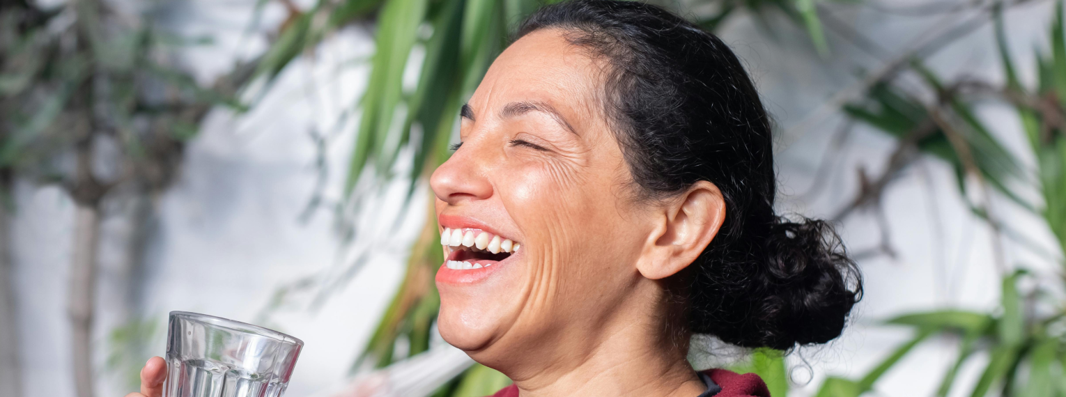 Eine Frau ohne fehlende Zähne lacht.