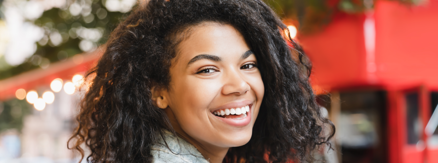 Eine Frau lächelt und zeigt dabei ihre Zähne.